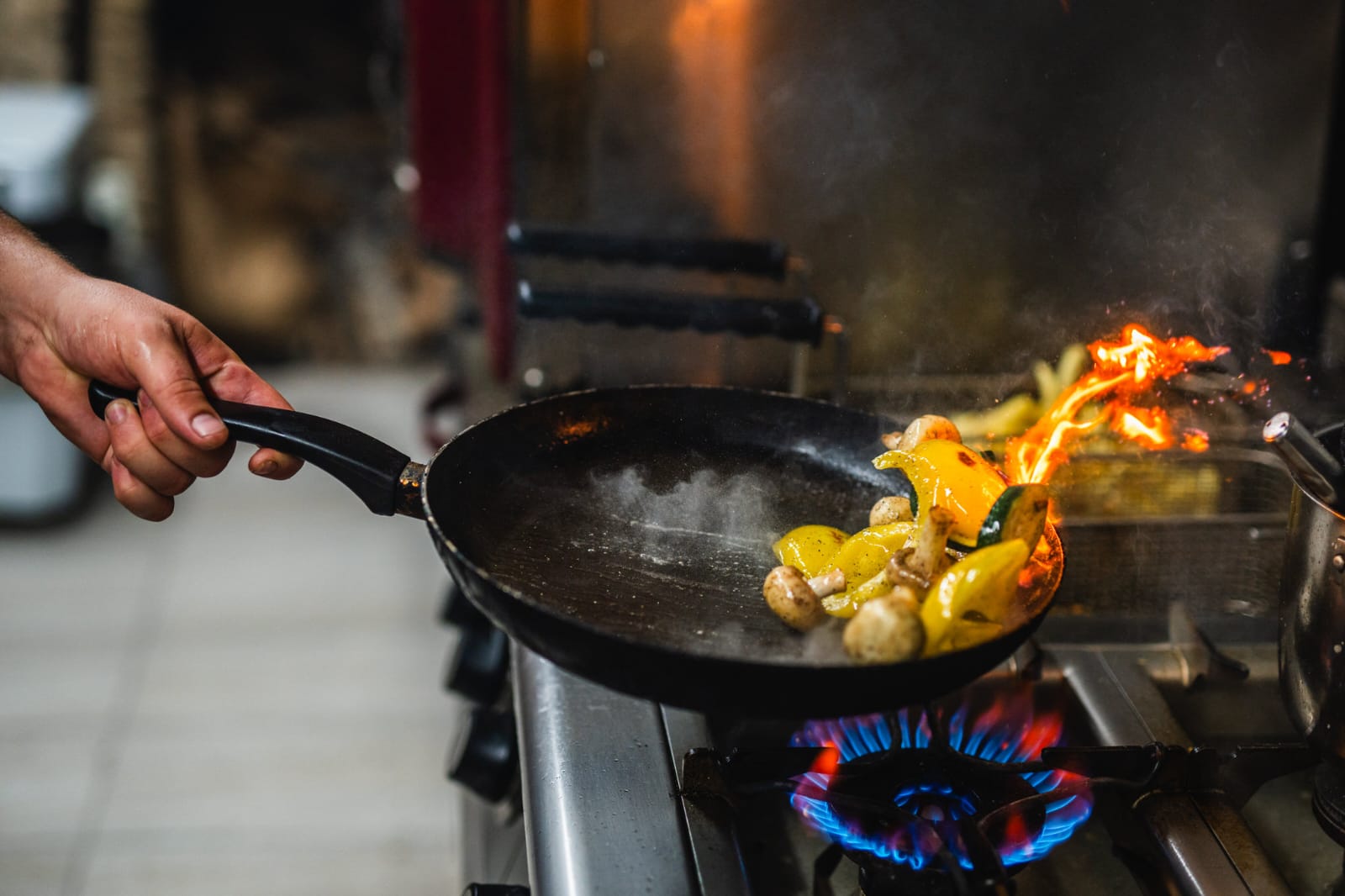 Flambé pan over open flame in the Roko kitchen