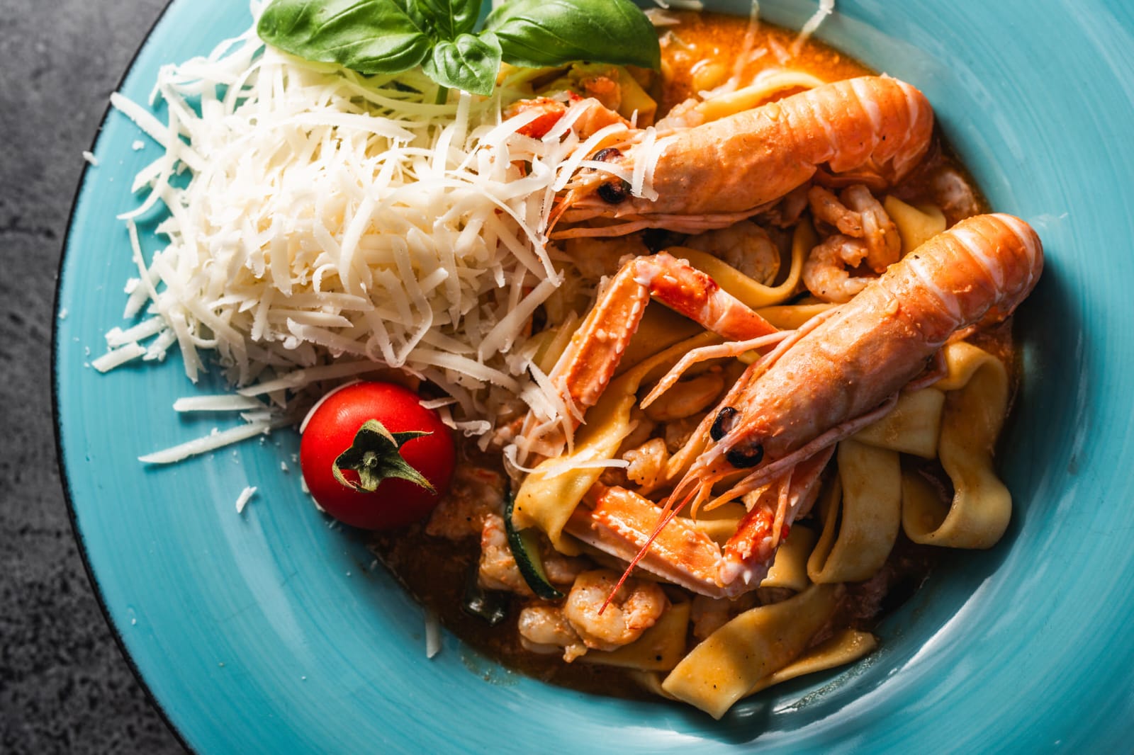 Seafood pasta with shrimp on turquoise plate